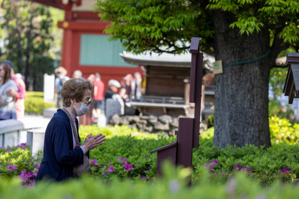 Tokyo, Japan-April 28,2024: Old women praying in Japanese temples. Spending a long time for praying