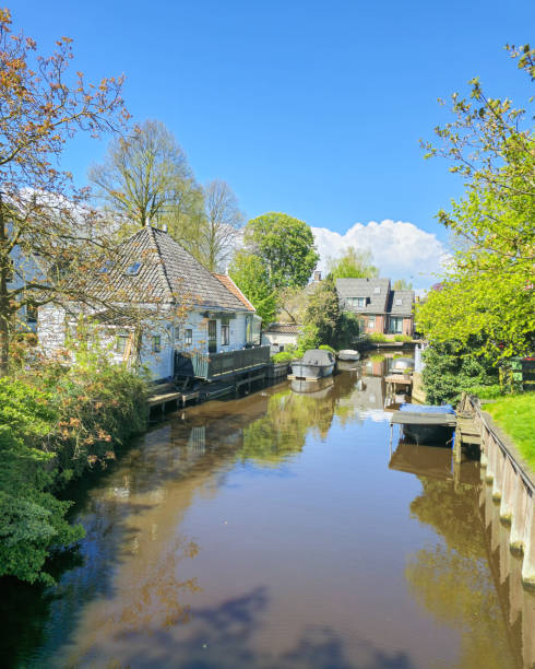 istock A winding river gracefully flows through a vibrant green landscape, surrounded by lush trees, grassy meadows, and rolling hills under a clear blue sky 2151562037