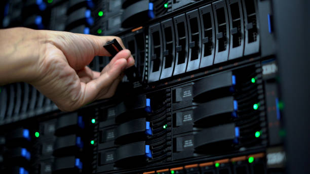 istock Close-up of a technician's hand installing a server hard drive in a data center, showcasing detailed server maintenance and management. 2151569871