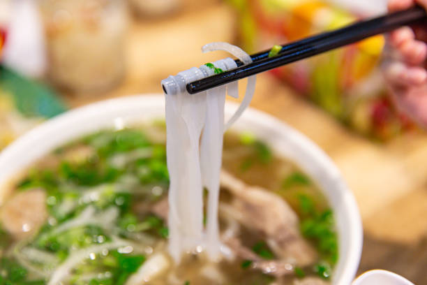 istock Vietnamese Pho Noodles Picked Up with Chopsticks Showcasing Texture 2151571155