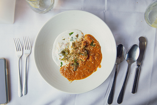 Sophisticated Presentation of a Rich Indian Curry, Butter Chicken or Lamb, Served with Basmati Rice and Raita