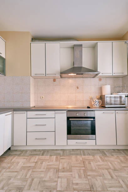 istock Minimalist kitchen with hood over stove and cabinets 2151573318