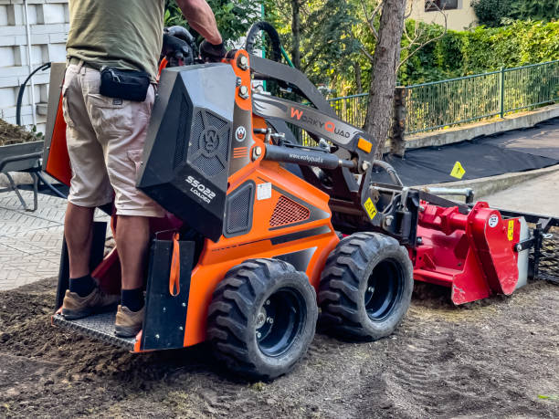 A municipal worker sows a lawn using a Boxer mechanical seeder. Planting a lawn. Nitra, Slovakia - 08.15.2023: A municipal worker sows a lawn using a Boxer mechanical seeder. Planting a lawn. lawn seeder stock pictures, royalty-free photos & images