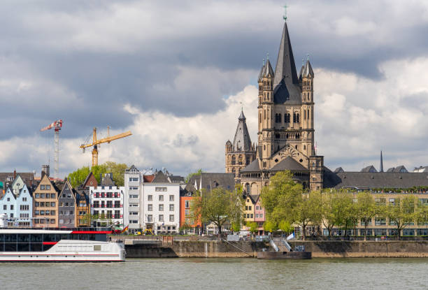 Cologne, Germany, April 2024: View to the Old Town with the church Groß St. Martin (Great St. Martin) from the right side of the Rhine River