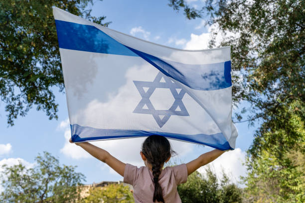 istock Back View On Child Holding Israeli Flag High. 2151580771