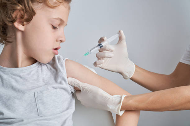 istock Faceless nurse injecting kid with syringe 2151591579