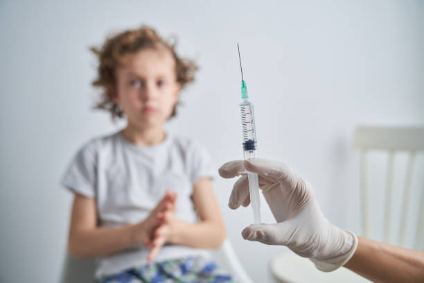 istock Faceless medic with syringe near child 2151591625