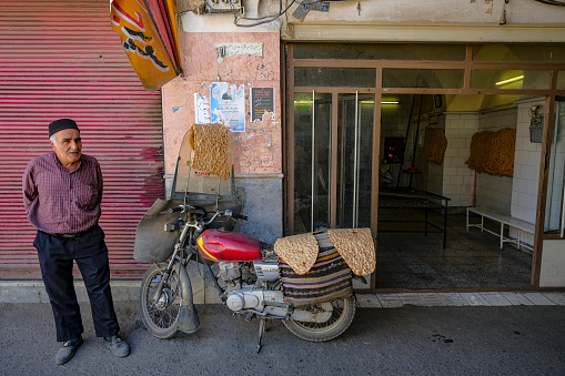 Qom, Iran - April 6, 2024: A man buying bread at a bakery in Qom, Iran.