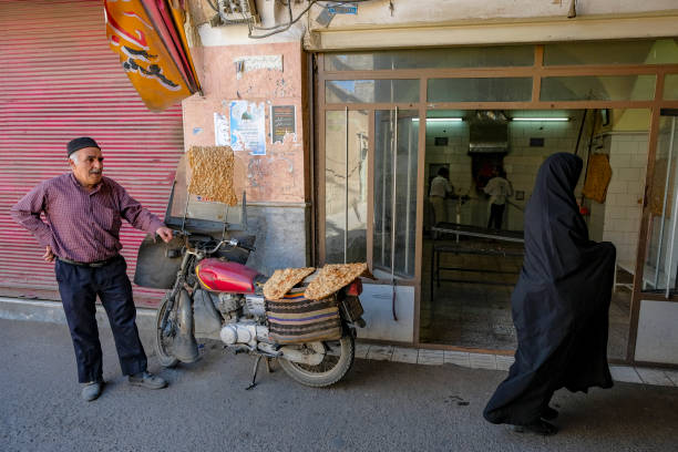 Qom, Iran - April 6, 2024: A man buying bread at a bakery in Qom, Iran.