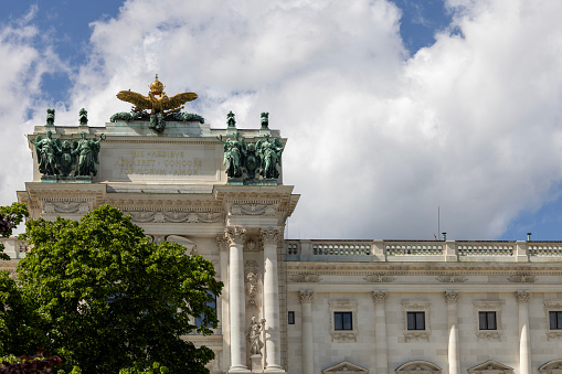 Vienna, Austria - April 26, 2024: Baroque Hofburg palace, Neue Burg from the Palace Gardens, statues on top. It is former principal imperial palace of the Habsburg dynasty