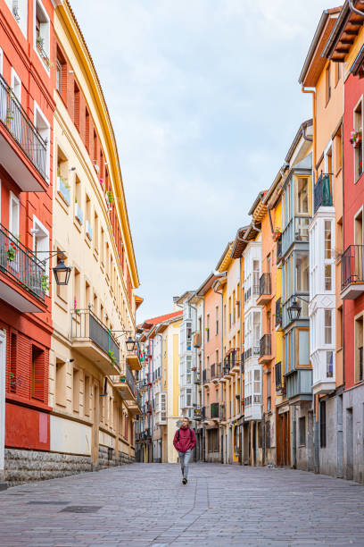 April 24th, 2024. Vitoria, Spain. A pedestrian street with one young man between colorful buildings.