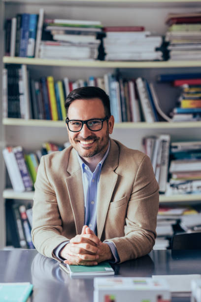 istock Professional Businessman Smiling in a Book-filled Office 2151609618