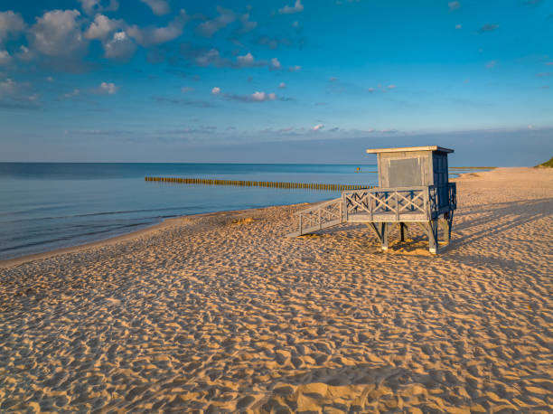 istock Lifeguard hut at sunrise on beach by Sea 2151613993