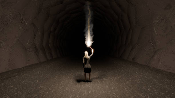Woman looking down long dark cave.