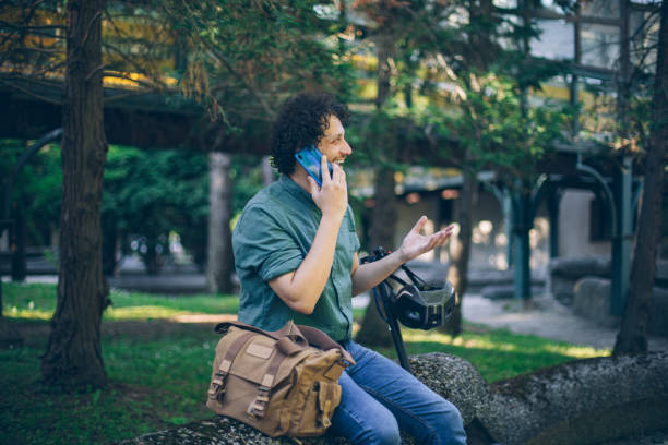 Young business man talking on phone on his way to work with e-scooter