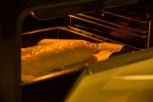 Closeup photo of pie baking in oven at kitchen.