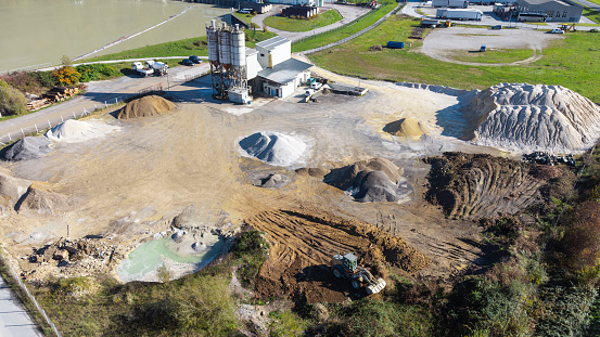 Aerial view of a construction materials site with piles of sand, gravel, and machinery