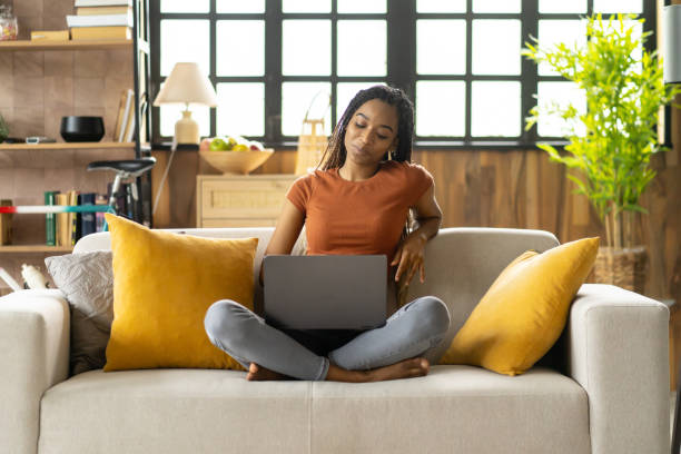 istock A millennial girl is learning sitting on sofa at home 2151625308