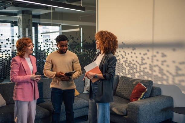 istock Interracial office staff standing at office lounge and discussing project 2151625351