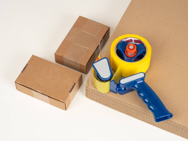 istock Packing tape dispenser. Small cardboard boxes. Packing materials. Cardboard for delivery service. Packing tape dispenser for owner of online store. Boxes for courier service. Assembly mail containers 2151630109