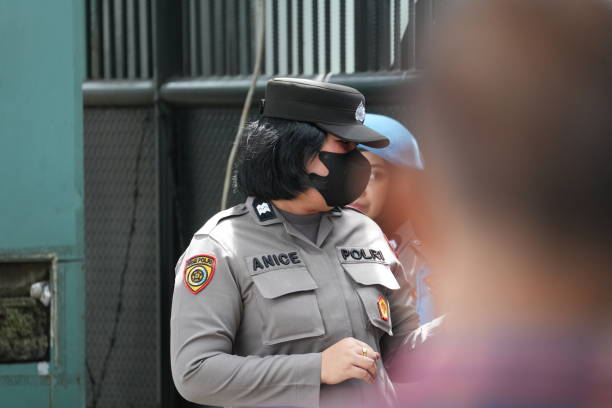 One man only / full length / rear view / back of 30-39 years old adult handsome people caucasian male / young men police force / security staff standing wearing uniform / necktie / hat / badge who is serious / confidence / concentration / looking who is searching and using flashlight / crime