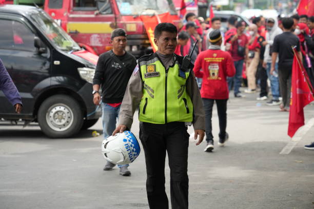 Makassar, Indonesia - May 1 2024: Indonesian police officers wearing full uniforms are standing guard on the streets