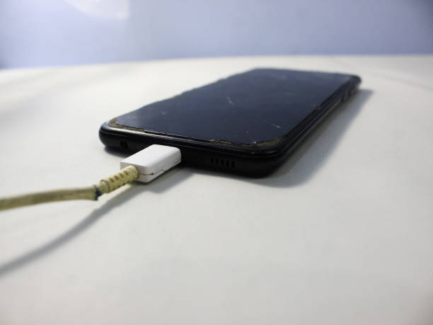 istock Old charger cable broken and smartphone, Defective charging cord, 2151638976