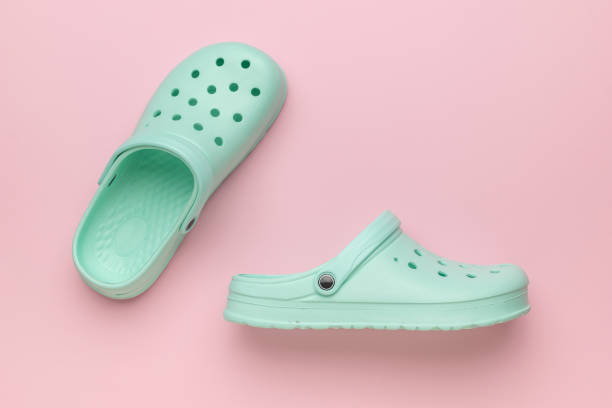 istock A pair of green rubber flip-flops on a pink background. 2151639566