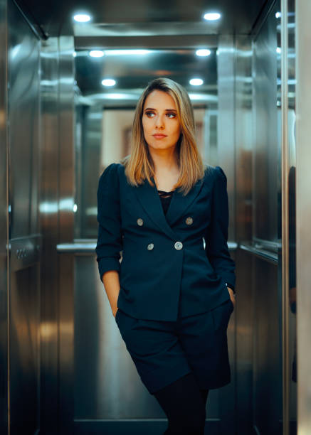 istock Businesswoman Standing in Elevator with Hands in the Pockets 2151642410