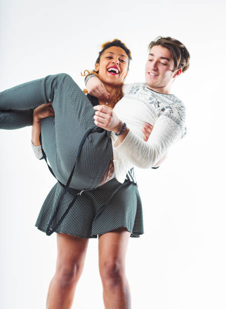 Playful reversal as a young woman supports a man in her arms, both sharing joyful laughter in a spirited moment