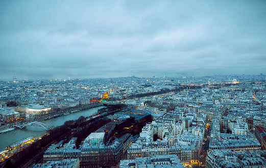As dusk falls over Paris in winter, the city is bathed in a serene blue light, while golden hues illuminate iconic landmarks like the Seine, Les Invalides, and Montmartre's Basilica