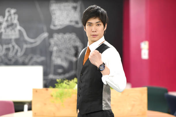 Smiling young Asian office worker doing a fist pump in the office