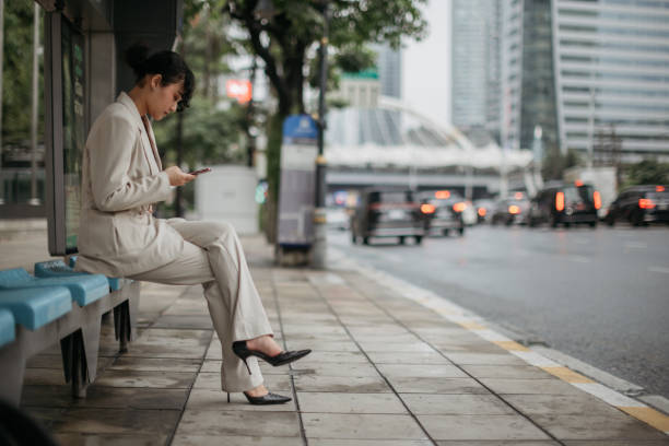 istock Busiensswoman using phone at the bus station 2151649352