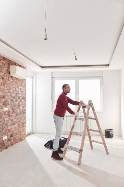 istock Handyman electrician with ladders working in a new home interior. 2151652764