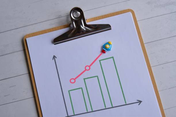 Top view image of rocket and graph on wooden table.