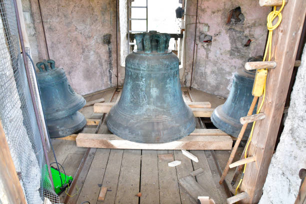 istock Three church bells rest on a wooden floor within the building 2151652986