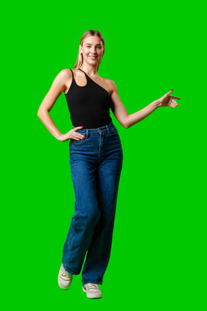 istock Young Woman Pointing at Something against green background 2151655647