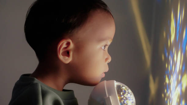 istock Baby boy playing projection light in bedroom 2151655824