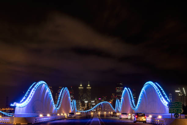 Des Moines, Iowa - United States - September 16th, 2024: The Iowa Women of Achievement Bridge at night with downtown in the background.