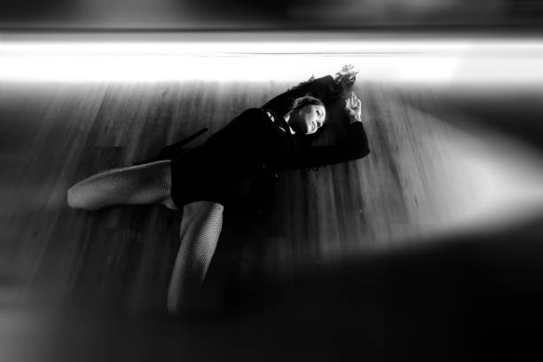 Dance Sport. A man warms up by doing stretching in a gym with mirrors. Black and white photo in retro style.