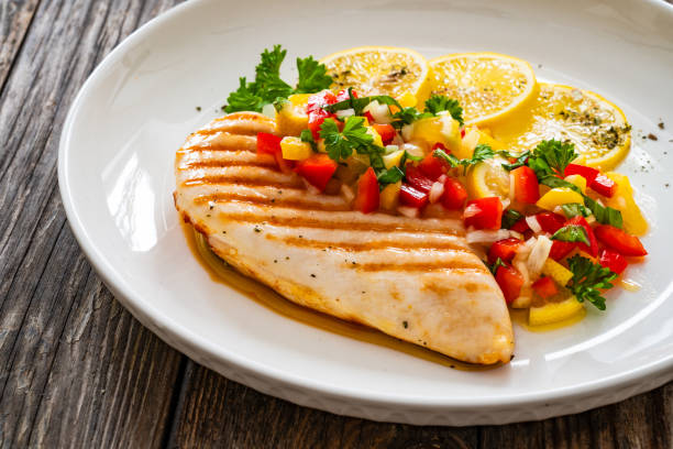 istock Grilled chicken breast and fresh vegetables on wooden table 2151657108