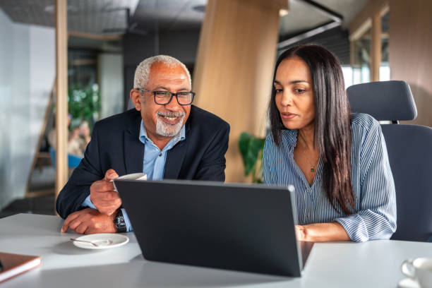 istock Senior Diverse Executives Engage with Laptop in Modern Office 2151658587