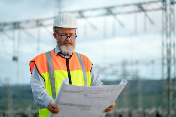 istock Electrical engineer with a blueprint working at the power station 2151659138