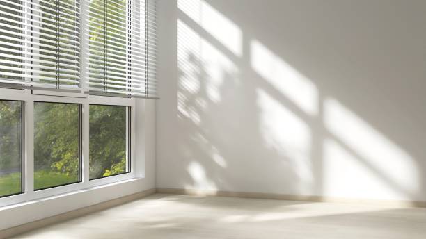 istock Empty room with white wall in sunlight from window blind, tree shadow on wood laminated floor 2151663379