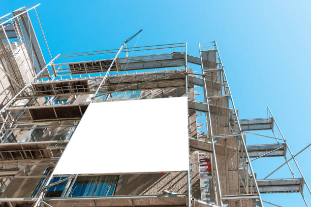 istock Blank white mockup advertisement hanging on the modern building under construction. Reconstruction of a building with white billboard. 2151663864