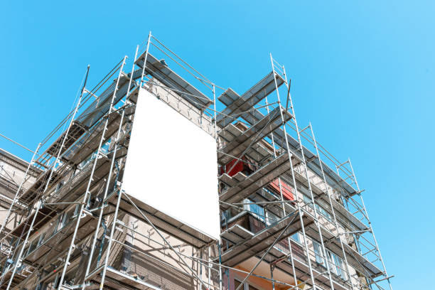 istock Blank white mockup advertisement hanging on the modern building under construction. Reconstruction of a building with white billboard. 2151664116