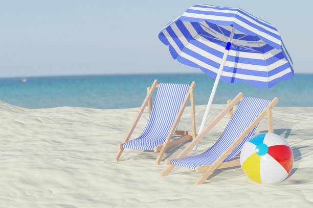 istock Two chairs and a beach ball under an umbrella at the beach 2151669745