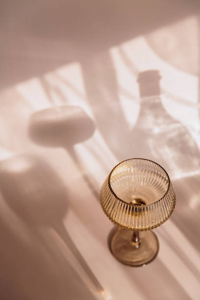 istock Two glasses with white wine placed on light beige background with shadows 2151670040