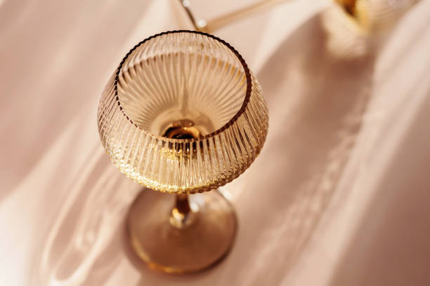 istock Two glasses with white wine placed on light beige background with shadows 2151670057