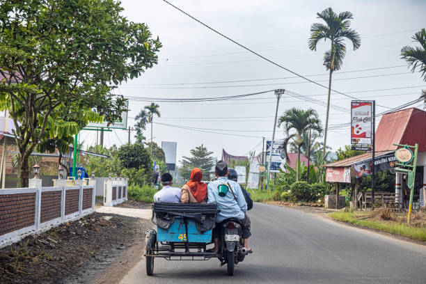 Kecamatan Harau, West Sumatra, Indonesia - February 10th 2024:   Motorcycle with a sidecar with passengers serving as a taxi seen from a following car